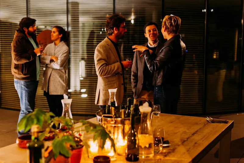 Colleagues chatting over drinks at a warm, candlelit networking evening