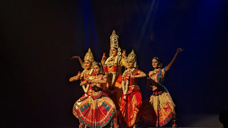 Classical dance troupe in ornate costumes and crowns performing on stage
