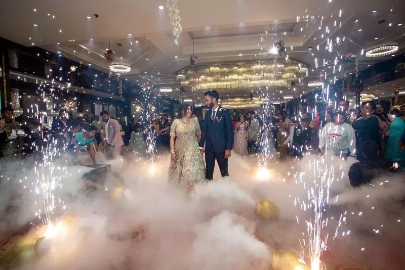 Couple making a grand entry through a banquet hall with cold-pyro sparklers and low fog