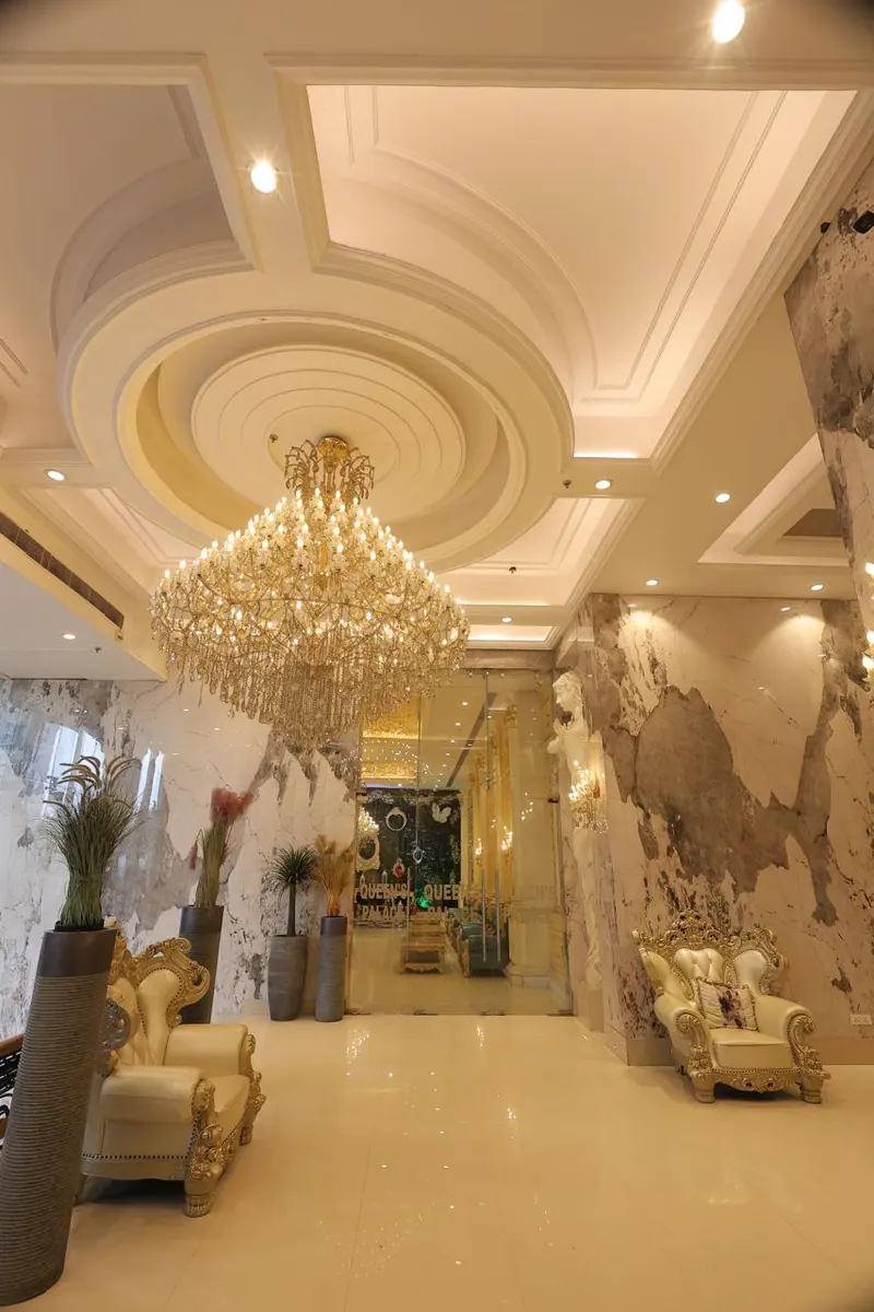 Marble lobby with a crystal chandelier and ivory armchairs