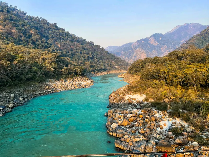 Turquoise Ganga winding between forested hills near Rishikesh