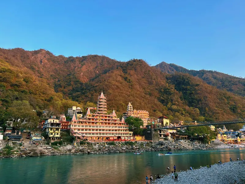 Rishikesh's tiered riverside temple on the Ganga beneath forested hills