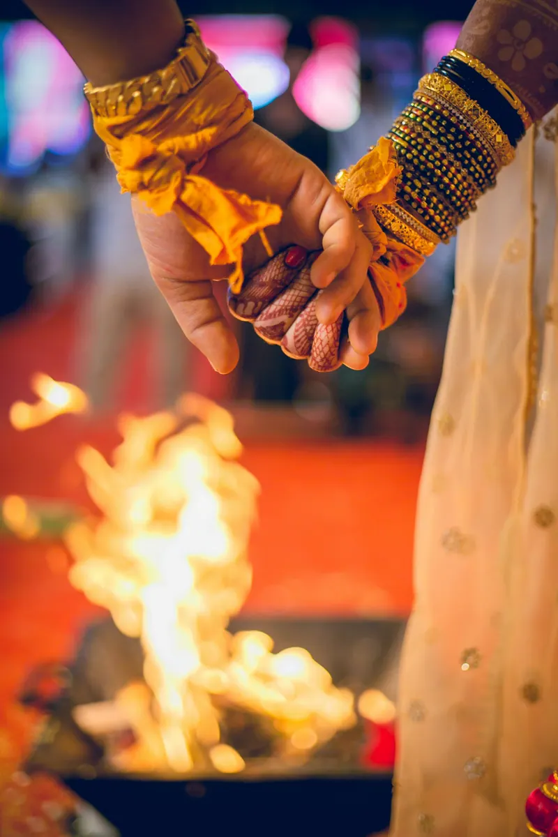 Close-up of the bride and groom's joined hands above the flames of the sacred havan fire